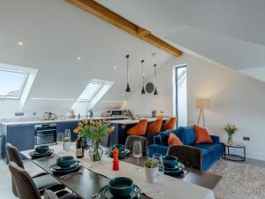 a kitchen and living room with a table and a blue couch at Scilla - Uk50179 in Helston