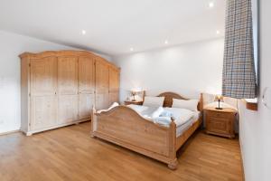 a bedroom with a large bed and a wooden cabinet at Ferienhaus Region Tegernsee in Eben