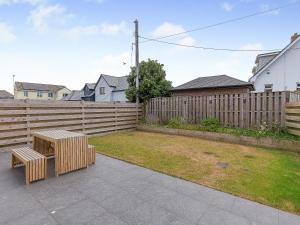 a backyard with a wooden fence and two benches at Scilla - Uk50179 in Helston +25 photos