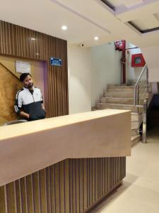 新德里Paharganj Stay - Main Bazar的一名男子在建筑物内用手机通话