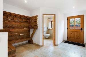 a bathroom with a toilet and a wooden wall at Ferienhaus Region Tegernsee in Eben +34 photos