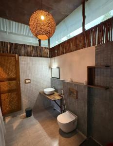 ein Badezimmer mit Toilette, Waschbecken und Kronleuchter in der Unterkunft Octopus Garden Dive Resort in Havelock Island