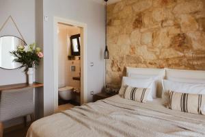 a bedroom with a bed and a stone wall at Orama Luxury Villa 4 Bedrooms with Private Pool in Hersonissos +66 photos