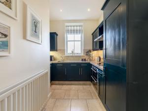 a kitchen with black cabinets and a sink at Longlands - Uk49289 in Preston