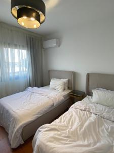 a room with two beds and a chandelier at Mango in Madinaty