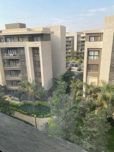 a view of a building with palm trees and buildings at Mango in Madinaty