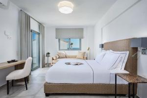 1 dormitorio con 1 cama blanca grande, escritorio y silla en Quattro Suites, en Monemvasia 46 fotos más