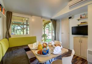 a living room with a table with food on it at Valamar Camping Lanterna - Adriacamps in Poreč