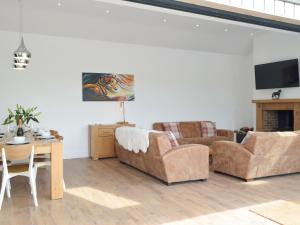 a living room with two couches and a table at Manor Lodge Stables in Wiston