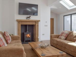 a living room with two couches and a fireplace at Manor Lodge Stables in Wiston