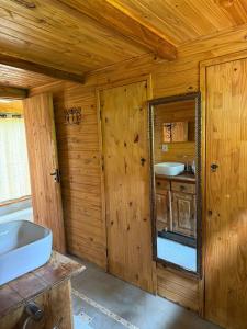 a bathroom with a mirror and a sink at POUSADA PARAISO DOS TUCANOS in Aiuruoca