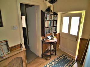 a room with a door and a table and a book shelf at Tigh Na Maraiche in Craighouse
