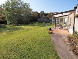a person sitting on a bench in a yard at Tigh Na Maraiche in Craighouse
