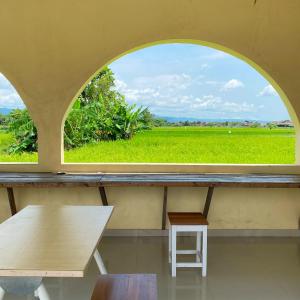 an arched window in a room with a table and bench at Vikosa Villa Private Pool With View in Yogyakarta