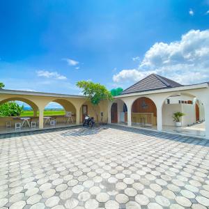 a building with a patio with tables and chairs at Vikosa Villa Private Pool With View in Yogyakarta