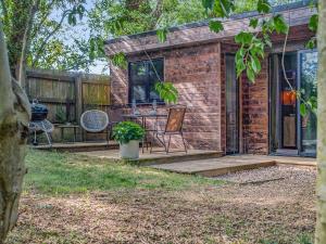 a tiny house with a porch and a patio at The Lodge In The Woods in Raithby