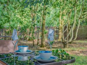 a table with two cups and saucers on it at The Lodge In The Woods in Raithby