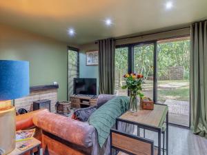 a living room with a couch and a table at The Lodge In The Woods in Raithby
