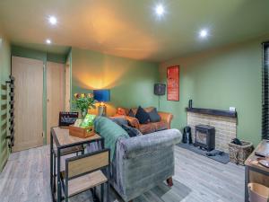 a living room with a couch and a fireplace at The Lodge In The Woods in Raithby