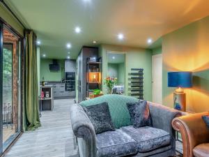 a living room with a couch and a kitchen at The Lodge In The Woods in Raithby +8 photos