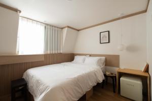 a bedroom with a large white bed and a window at stay105행궁 in Suwon
