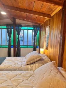 a bedroom with two beds and two windows at YogaLife in Mercedes