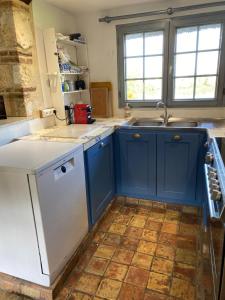 Chaumière 6-8p, 4ch, proche Honfleur في Conteville: مطبخ مع دواليب زرقاء وغسالة صحون بيضاء