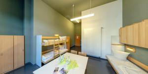 a room with a table and a bunk bed at DJH Jugendherberge Chemnitz "eins" in Chemnitz