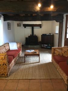 ein Wohnzimmer mit zwei Sofas und einem Couchtisch in der Unterkunft Grange Cottage in Saint-Dolay