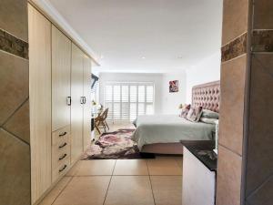 ein Schlafzimmer mit einem Bett und einer Kommode darin in der Unterkunft Central Beach Stay Ultimate Holiday Spot in Jeffreys Bay