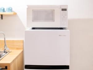 a microwave on top of a refrigerator in a kitchen at Hotel art rock in Takamatsu +26 photos