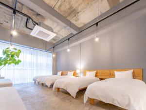 a room with four beds in a row with lights at Hotel art rock in Takamatsu