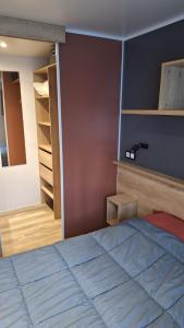 a bedroom with a bed and some shelves at MH539 La Cabane des vagues in Saint-Julien-en-Born +19 photos