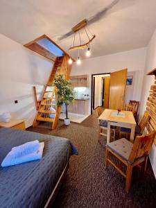 a bedroom with a bed and a table and a staircase at Penzion Mona Rooms & Apartments in Harrachov