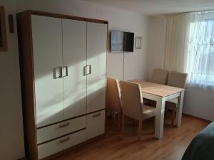 a dining room with a table and a large cabinet at Ubytovanie Otília in Zuberec
