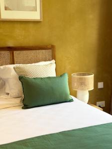 a bed with a green pillow on top of it at Lorlagon by LOV Mauritius in Trou dʼ Eau Douce