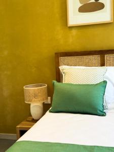 a bed with a green and white pillow and a lamp at Lorlagon by LOV Mauritius in Trou dʼ Eau Douce