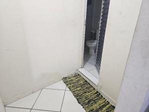 a bathroom with a toilet and a rug on the floor at Itapecerica da Serra perto de Embu das artes e Cotia in Itapecerica da Serra