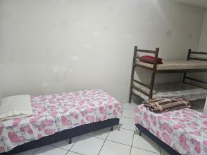 a bedroom with two beds and a chair at Itapecerica da Serra perto de Embu das artes e Cotia in Itapecerica da Serra