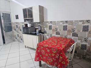 a kitchen with a table with a red table cloth at Itapecerica da Serra perto de Embu das artes e Cotia in Itapecerica da Serra