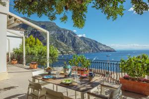 a table on a balcony with a view of the ocean at POSEA Collection - Villa La Nice in Positano