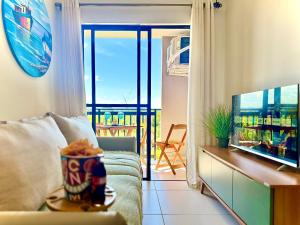 a living room with a couch and a flat screen tv at Apto 2 Quartos PISCINA Churrasqueira Wi-Fi Ar Condicionado Cozinha Complata Vaga de Garagem 400m PRAIA Ideal para Famílias ou Amigos Reserve Agora in Piçarras