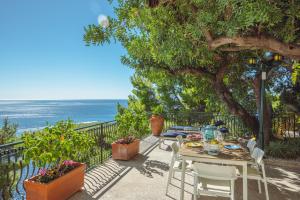 a table and chairs on a patio overlooking the ocean at POSEA Collection - Villa La Nice in Positano +55 photos