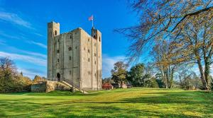 un château avec un drapeau en haut dans l'établissement Beautiful Cottage opposite Hedingham Castle!, à Castle Hedingham