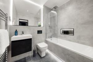 a bathroom with a sink and a toilet and a bath tub at Modern 4 Bed 4 Bath Home in Reading Perfect for Business and Contractors with Free Parking! in Reading