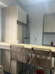 Depto San Lorenzo y Alberdi في سان ميغيل دي توكومان: مطبخ مع كونتر مع كرسيين وثلاجة