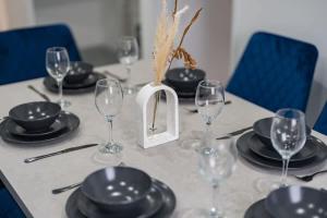 a table with plates and wine glasses on it at Spacious 4 Bed House in Birmingham City Centre, Ideal for long term with Free Parking in Birmingham