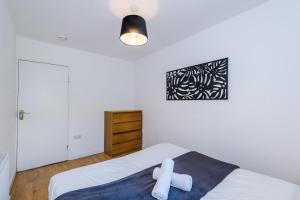 a bedroom with a white bed with a cross on it at Spacious 4 Bed House in Birmingham City Centre, Ideal for long term with Free Parking in Birmingham
