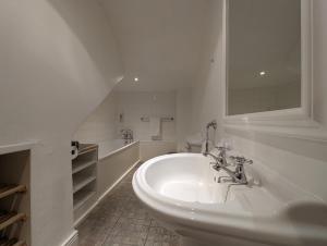 a white bathroom with a sink and a tub at Pass the Keys Charming 3-Bed Converted Basement Tynemouth in Tynemouth +22 photos