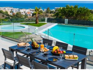 a table with food on it next to a swimming pool at Orama Luxury Villa 4 Bedrooms with Private Pool in Hersonissos